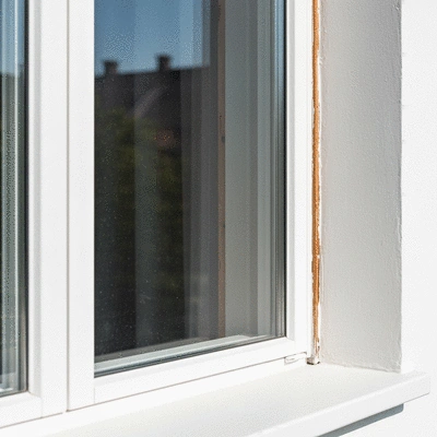 Gros plan sur une vieille fenêtre en bois rénovée, avec une nouvelle couche de peinture et un vitrage moderne, lumière naturelle
